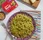 Pesto pasta in a bowl with a Dorot basil pack, nuts, and cheese on a board.